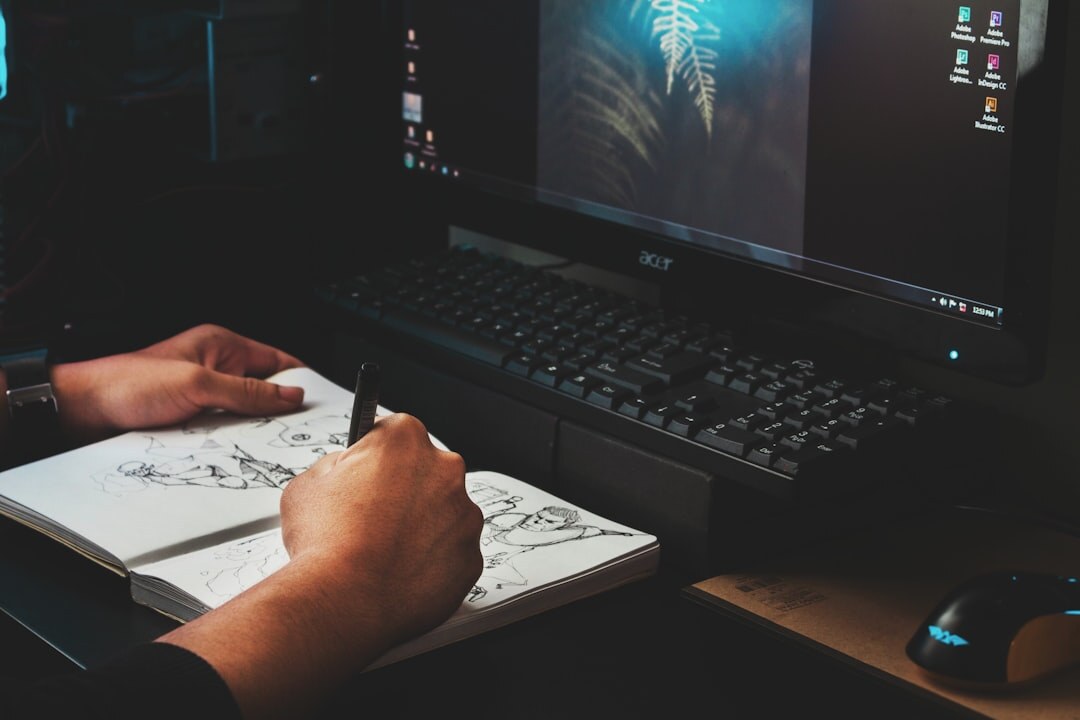 Hands typing on a laptop next to a printed storyboard and script pages